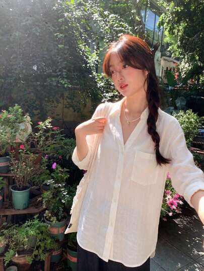 Áo sơ mi nữ dáng rộng tay dài cài cúc, cổ cao màu trắng, trang phục mùa hè thường ngày.