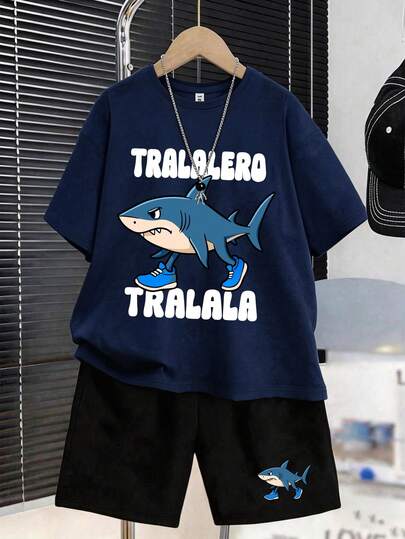 一套男童短袖T恤和运动裤套装，印有TRALALA卡通蓝色鲨鱼图案，是完美的夏季礼物，适合春夏上学和户外活动穿着。