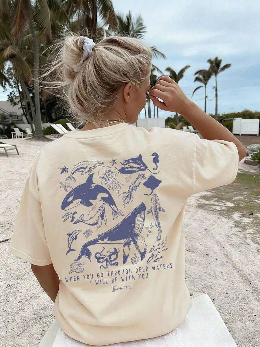 Women's Summer Short-Sleeved T-Shirt With A Casual Marine Animal Print Featuring Sharks, Dolphins, And Starfish. It Has A Round Neck, A Loose And Versatile Fit, And Is Beige In Color. Ideal For Everyday Wear And Vacations. Unisex. - 杏 - 查看 1