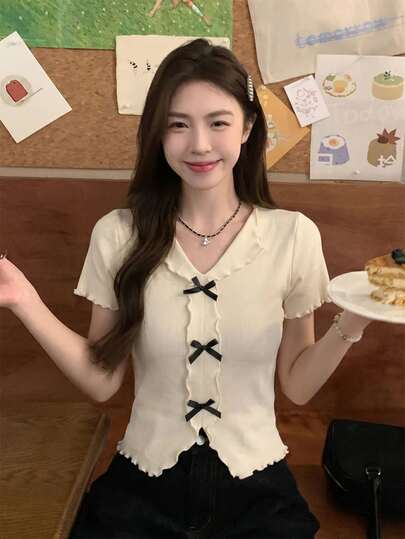 Áo dệt kim tay ngắn cổ chữ V tối giản, gợi cảm kiểu Hàn Quốc mùa hè, điểm nhấn là viền bèo nhún và nơ, ôm sát tôn dáng, thích hợp cho các buổi đi chơi, tiệc trà chiều, kỳ nghỉ và hẹn hò.
