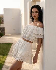 Rouah Zweistufiges Broderie Anglaise Crop Top mit Off-Shoulder Ausschnitt in Weiß. Genießen Sie sonnendurchflutete Tage mit diesem himmlischen weißen Broderie Anglaise Crop Top, das eine perfekte Harmonie aus Textur und verspieltem Design ist. Aus feinem Lochstickstoff gefertigt, verkörpert dieses Stück einen mühelosen Boho-Geist für Ihren nächsten Sommerurlaub. - Weiss - Übersicht 1