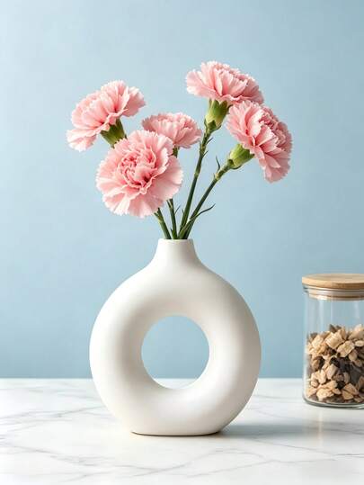 1 chiếc bình hoa hình bánh donut màu trắng, thiết kế rỗng tối giản hiện đại, thích hợp để trang trí nhà cửa hoặc đặt trên bàn làm việc.