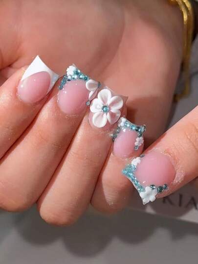 Bộ 10 miếng dán móng tay vuông ngắn, màu hồng nhạt với đầu móng kiểu Pháp màu trắng, được trang trí bằng hoa trắng 3D và đá pha lê hình đám mây màu xanh dương, có bề mặt bóng và thiết kế có thể tái sử dụng. Mang đến vẻ đẹp nữ tính thanh lịch, phù hợp cho sử dụng hàng ngày, hẹn hò và kỳ nghỉ hè. Miếng dán móng tay được làm thủ công tỉ mỉ, món quà hoàn hảo dành cho phụ nữ và các cô gái.