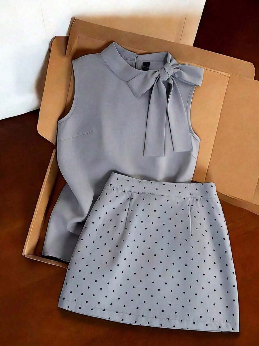 Conjunto de viaje de color gris claro, top sin mangas de cuello alto combinado con falda mini de lunares. Silueta ajustada minimalista que acentúa la cintura. Tela suave y fluida. El detalle del lazo en la top y los lunares distribuidos uni - Multicolor - Ver 1