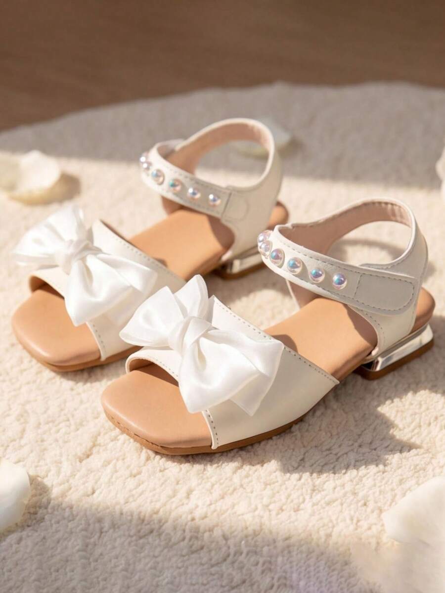 2026 Zapatos esenciales versátiles de moda para niñas de 3 a 8 años - Material de PU suave color beige claro, gran lazo y decoración de perla brillante, suela de goma antideslizante, tacón bajo - Estilo elegante de princesa - Adecuado para la escuela, fiestas y sandalias de princesa para primavera/verano al aire libre! - Blanco - Ver 1