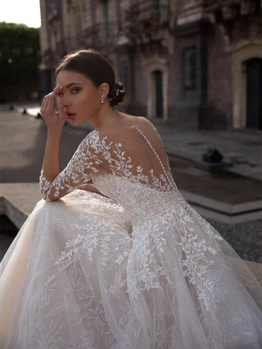 Elegant A-Line Wedding Dress With Illusion Long Sleeves, V-Neckline, Sheer Lace Appliques With Floral Embroidery, Button-Down Back, And Voluminous Tulle Skirt With Cathedral Train For Formal Church, Ballroom, Or Garden Ceremonies In Spring And Summer. This Romantic Bridal Gown Features A Fitted Bodice Crafted From Delicate Sheer Lace Adorned With Intricate Floral Embroidery, Creating A Timeless And Sophisticated Look - 白色 - 查看 1