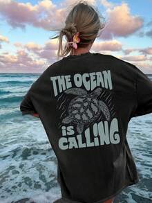 Reversible Printed T-Shirt For Women, Perfect For Spring And Summer. A Versatile And Stylish Top With A Vintage Design Featuring Sea Turtles And Ocean Elements. This Crew Neck, Short-Sleeved, Oversized T-Shirt Features The Slogan 'THE OCEAN IS CALLING'. - Black - View 4