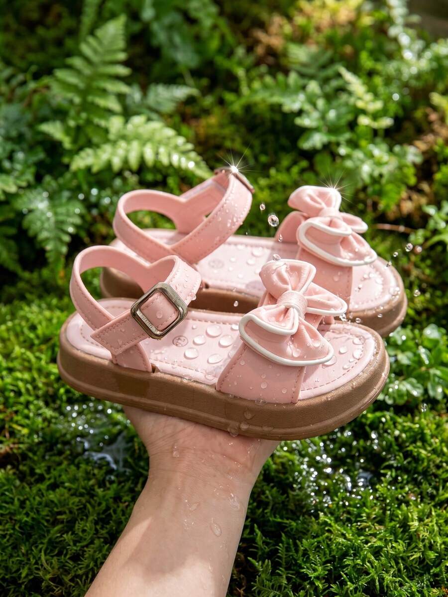 Giày sandal công chúa mùa hè cho bé gái, giày đi biển mùa hè cho trẻ em, giày hở mũi, sandal đế bằng thời trang có nơ, màu hồng.