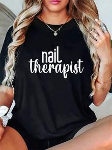 Ropa de Mujer, Camiseta de Manicurista con Estampado de Letras - Top Holgado Casual de Cuello Redondo y Manga Corta, con diseños de arte de uñas y patrones de texto de manicurista, ropa de trabajo transpirable para primavera/verano adecuada para salones de uñas, lavable a máquina para un ajuste cómodo, estampado de carácter social a la moda, corte relajado adecuado para terapeutas de uñas y profesionales de la belleza, atuendo casual elegante. - Negro - Ver 1