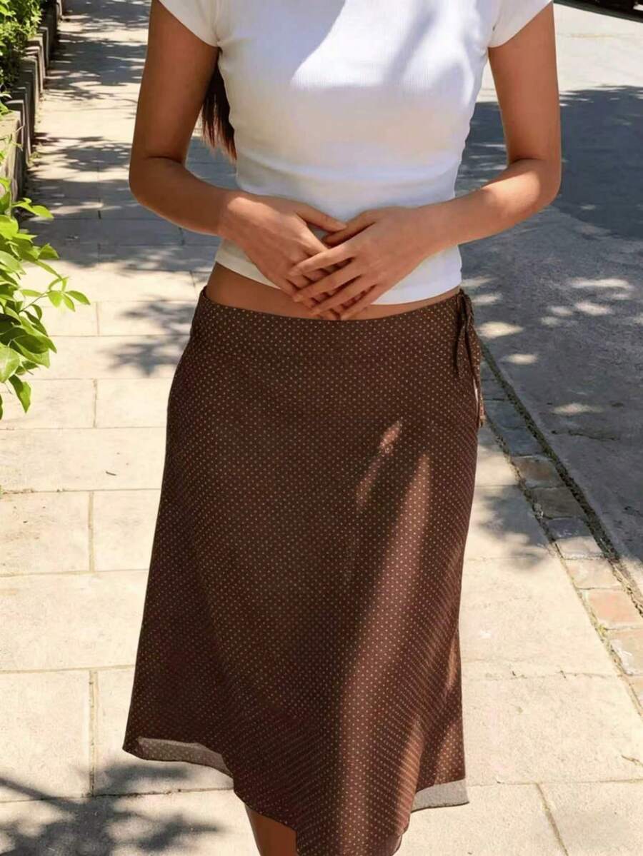 Chân váy midi chữ A chấm bi màu cà phê dành cho nữ này được làm từ vải polyester, mang phong cách giản dị nhưng thanh lịch, với các chi tiết lưới tương phản tinh tế và thiết kế không xẻ tà. - Cà phê nâu - Xem 1