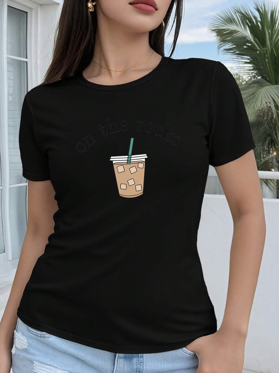 Camiseta de mujer de algodón puro con estampado, que presenta un diseño geométrico 2D de un vaso de bebida helada con la palabra "on the ros" impresa en ella. Es una camiseta casual de manga corta y cuello redondo, adecuada para todas las estaciones, disponible en varios colores y tallas. Cuenta con un estilo festivo, moderno y retro, material transpirable y estampados divertidos. - Negro - Ver 1