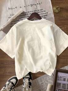 Una camiseta de manga corta para mujer con estilo retro americano, de corte holgado y con diseño estampado (los pantalones son solo para sugerencias de estilo). Esta pieza sencilla y elegante presenta un patrón de letras impresas con temática tropical, lo que la convierte en un elemento imprescindible para crear un look relajado de vacaciones, perfecto para ocasiones como el Día del Trabajo y el Día de la Independencia de México. - Beis - Ver 2