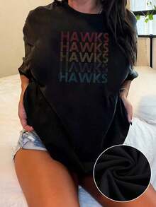 The Image Shows The Word HAWKS Repeated In Colored Lines That Symbolize Energy, Freedom, And Strength With A Modern Style That Conveys Movement And Confidence. Women's T-Shirts, 100% Cotton, Soft, Comfortable, Casual Everyday Style, 184g - 黑色 - 查看 1