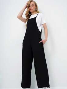 A Relaxed Sleeveless Jumpsuit Featuring A Wide-Leg Silhouette And Minimalist Spaghetti Straps For An Effortlessly Modern Look. Designed With Side Pockets And A Fluid Drape, This Versatile Piece Offers All-Day Comfort While Layering Perfectly Over Basic Tees For Easy Everyday Styling. - Black - View 5