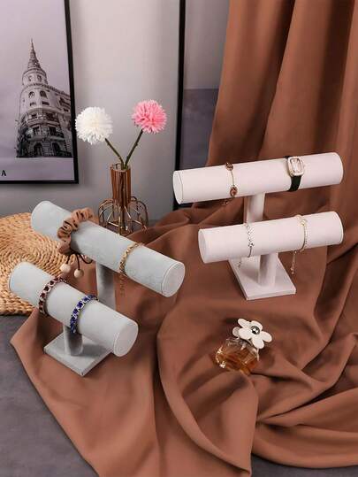 1 Giá đỡ trưng bày hình chữ T hai lớp phủ nhung, được thiết kế để trưng bày vòng tay, lắc tay, đồng hồ và các phụ kiện khác. Bề mặt phủ nhung đen mềm mại và tinh tế không chỉ chống trơn trượt và chống trầy xước mà còn giúp bảo vệ đồ trang sức khỏi bị hao mòn. Thiết kế hai tầng so le cho phép bạn trưng bày nhiều món đồ cùng một lúc, giúp bộ sưu tập của bạn được sắp xếp gọn gàng. Đế chắc chắn có thể đặt trên bàn trang điểm hoặc tủ mà không dễ bị đổ.