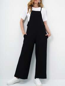 A Relaxed Sleeveless Jumpsuit Featuring A Wide-Leg Silhouette And Minimalist Spaghetti Straps For An Effortlessly Modern Look. Designed With Side Pockets And A Fluid Drape, This Versatile Piece Offers All-Day Comfort While Layering Perfectly Over Basic Tees For Easy Everyday Styling. - Black - View 4