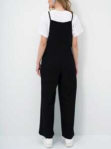 A Relaxed Sleeveless Jumpsuit Featuring A Wide-Leg Silhouette And Minimalist Spaghetti Straps For An Effortlessly Modern Look. Designed With Side Pockets And A Fluid Drape, This Versatile Piece Offers All-Day Comfort While Layering Perfectly Over Basic Tees For Easy Everyday Styling. - Black - View 6