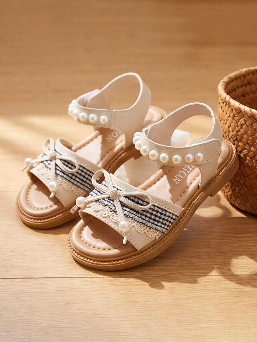 Gợi ý sản phẩm bán chạy nhất: Sandal trẻ em Little Flamingo Bowknot - Họa tiết kẻ caro đen trắng tinh tế + viền ren - Dễ dàng mang vào và tháo ra với khóa dán. Hoàn hảo để phối cùng áo phông và chân váy xếp ly. Sandal trẻ em nhẹ nhàng và tinh tế! - Màu be - Xem 1