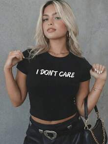 White Fitted Cropped T-Shirt With A Crew Neck And A Graphic Print Featuring The Phrase "I Don't Care." It Has Short Sleeves And A Minimalist Style. Ideal For Spring And Summer, Perfect For The Office, Walks, Vacations, And Everyday Wear. A Versatile Women's Basic Blouse With A Casual Yet Elegant Style That Pairs Well With All Your Favorite Outfits. 8NYG - 黑色 - 查看 3