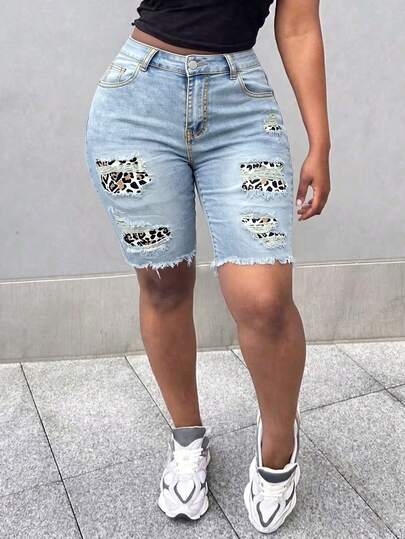 Quần short denim nữ dáng suông, màu xanh nhạt, có gấu quần cắt thô và chi tiết rách, độ co giãn vừa phải, thích hợp cho nữ.