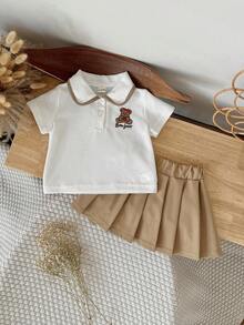 Bộ 2 món gồm áo polo trắng tay ngắn thêu hình gấu dễ thương cho bé gái và chân váy xếp ly màu nâu, thích hợp cho mùa hè. - trắng - Xem 7