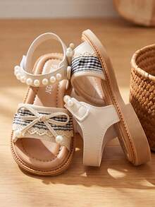 Gợi ý sản phẩm bán chạy nhất: Sandal trẻ em Little Flamingo Bowknot - Họa tiết kẻ caro đen trắng tinh tế + viền ren - Dễ dàng mang vào và tháo ra với khóa dán. Hoàn hảo để phối cùng áo phông và chân váy xếp ly. Sandal trẻ em nhẹ nhàng và tinh tế! - Màu be - Xem 3