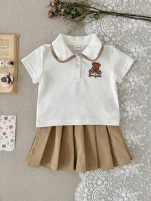 Bộ 2 món gồm áo polo trắng tay ngắn thêu hình gấu dễ thương cho bé gái và chân váy xếp ly màu nâu, thích hợp cho mùa hè. - trắng - Xem 1