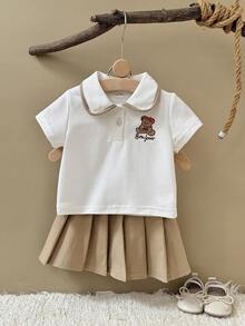 Bộ 2 món gồm áo polo trắng tay ngắn thêu hình gấu dễ thương cho bé gái và chân váy xếp ly màu nâu, thích hợp cho mùa hè. - trắng - Xem 2