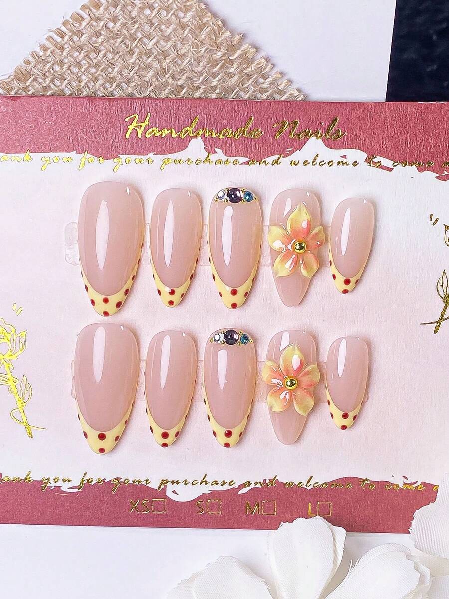 一套包含10片手工制作的杏仁形美甲贴片,款式多样:黄色法式底色搭配红色波点,黄色底色搭配粉色晕染,以及饰有金色珠子和彩色钻石的精美手工雕刻图案(无名指款)。 - 黃色 - 查看 1