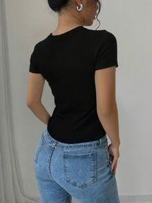 Top básico de manga corta con textura de canalé, corte ajustado que realza la figura y se adapta a cualquier tipo de cuerpo. Su tejido elástico ofrece máxima comodidad sin apretar, es transpirable y resistente, ideal para combinar con jeans, faldas o pantalones de vestir. Un prenda versátil para looks casuales, de oficina o salidas informales, que no pasa de moda y se convierte en tu favorito para cualquier ocasión - Negro - Ver 3