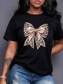 Un glamuroso lazo con estampado de leopardo y elegantes cintas rosas adornado con brillos refleja audacia sofisticación y feminidad una declaración de moda que celebra tu confianza y presencia única en cada momento Camiseta de mujer 220g,maija mujer curvy. - Negro - Ver 1