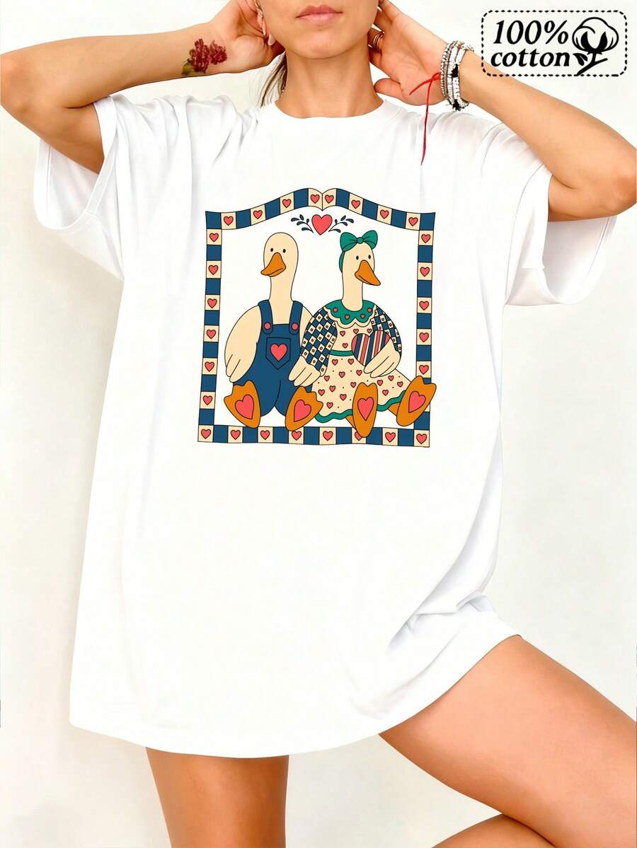 Camiseta blanca de mujer con una impresión frontal de unareja de pato dentro de un marco de corazón, diseñ para la comodidad y el uso informal durante las salidas diarias y el ocio
