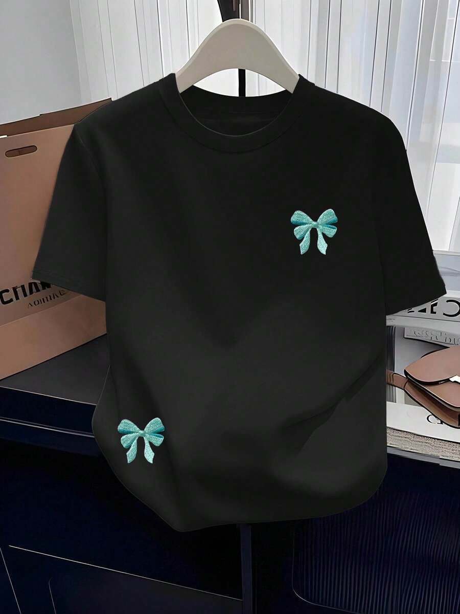 Camiseta Casual Versátil de Cuello Redondo para Mujer | Nueva Camiseta de Manga Corta con Cuello Redondo, Estampada, Sencilla y Moderna, con Patrón de Lazo Bordado de Imitación, Cómoda, para Todas las Temporadas, Estilo Vintage Urbano, Unisex, de Algodón, Corte Holgado. - Negro - Ver 1