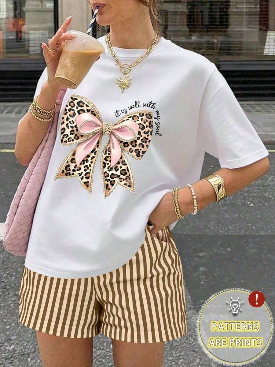 Una camiseta de manga corta para mujer con estilo retro americano, de corte holgado y con diseño estampado (los pantalones son solo para sugerencias de estilo). Esta pieza sencilla y elegante presenta un patrón de letras impresas con temática tropical, lo que la convierte en un elemento imprescindible para crear un look relajado de vacaciones, perfecto para ocasiones como el Día del Trabajo y el Día de la Independencia de México. - Blanco - Ver 1