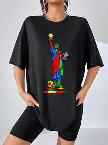 Figura colorida de la Estatua de la Libertad sosteniendo un balón dorado y una bandera de Estados Unidos sobre bloques multicolores que simbolizan unión y diversidad camiseta de mujer 100% algodón cómoda y moderna para uso casual - Negro - Ver 1