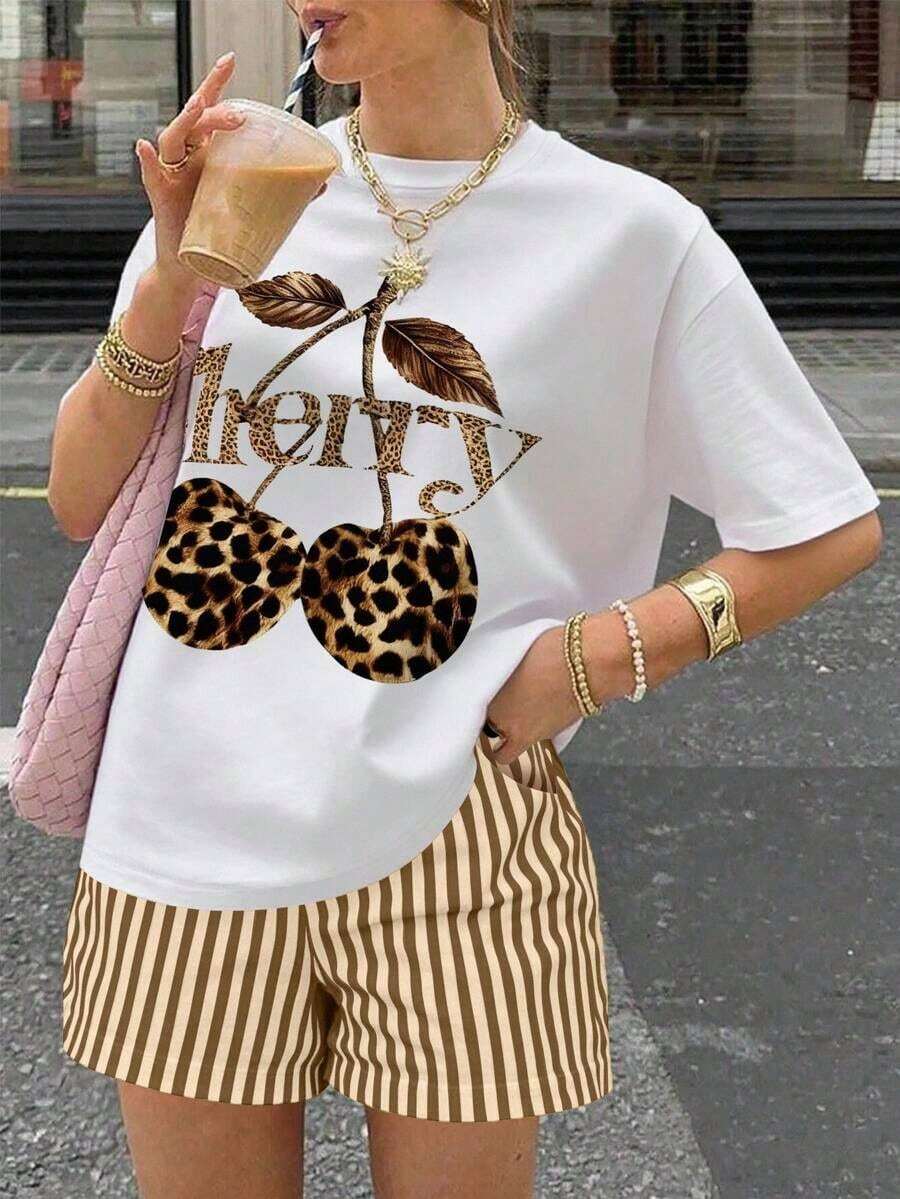 Una camiseta de manga corta para mujer con estilo retro americano, de corte holgado y con diseño estampado (los pantalones son solo para sugerencias de estilo). Esta pieza sencilla y elegante presenta un patrón de letras impresas con temática tropical, lo que la convierte en un elemento imprescindible para crear un look relajado de vacaciones, perfecto para ocasiones como el Día del Trabajo y el Día de la Independencia de México. - Blanco - Ver 1
