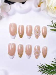 Bộ 10 móng giả dán thủ công hình hạnh nhân, màu trắng trong suốt kiểu Pháp. Sử dụng nền màu nude nhẹ nhàng, chúng được vẽ tay viền và đường kẻ kiểu Pháp màu trắng với bột gương vàng. Được chế tác bằng gel trong suốt thủ công, trang trí bằng hạt thép vàng và ngọc trai trắng. - Nhiều màu - Xem 5