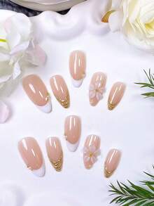 Bộ 10 móng giả dán thủ công hình hạnh nhân, màu trắng trong suốt kiểu Pháp. Sử dụng nền màu nude nhẹ nhàng, chúng được vẽ tay viền và đường kẻ kiểu Pháp màu trắng với bột gương vàng. Được chế tác bằng gel trong suốt thủ công, trang trí bằng hạt thép vàng và ngọc trai trắng. - Nhiều màu - Xem 3