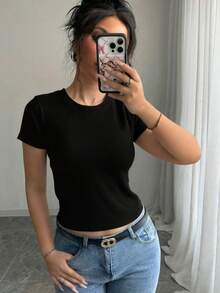 Top básico de manga corta con textura de canalé, corte ajustado que realza la figura y se adapta a cualquier tipo de cuerpo. Su tejido elástico ofrece máxima comodidad sin apretar, es transpirable y resistente, ideal para combinar con jeans, faldas o pantalones de vestir. Un prenda versátil para looks casuales, de oficina o salidas informales, que no pasa de moda y se convierte en tu favorito para cualquier ocasión - Negro - Ver 2