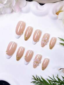 Bộ 10 móng giả dán thủ công hình hạnh nhân, màu trắng trong suốt kiểu Pháp. Sử dụng nền màu nude nhẹ nhàng, chúng được vẽ tay viền và đường kẻ kiểu Pháp màu trắng với bột gương vàng. Được chế tác bằng gel trong suốt thủ công, trang trí bằng hạt thép vàng và ngọc trai trắng. - Nhiều màu - Xem 4