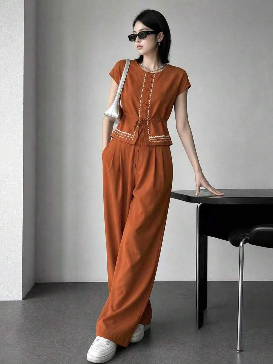 A&DD MODA, REF: AS1990 - Women's Set Consisting Of A Short-Sleeved Blouse And Pants. The Blouse Has A Round Neckline With Details And Buttons. The Pants Have A Straight Cut For A Slimming Effect. This Casual Yet Elegant Set Is Ideal For Special Occasions And Social Events, Creating A Complete And Sophisticated Look. - 鏽棕色 - 查看 1