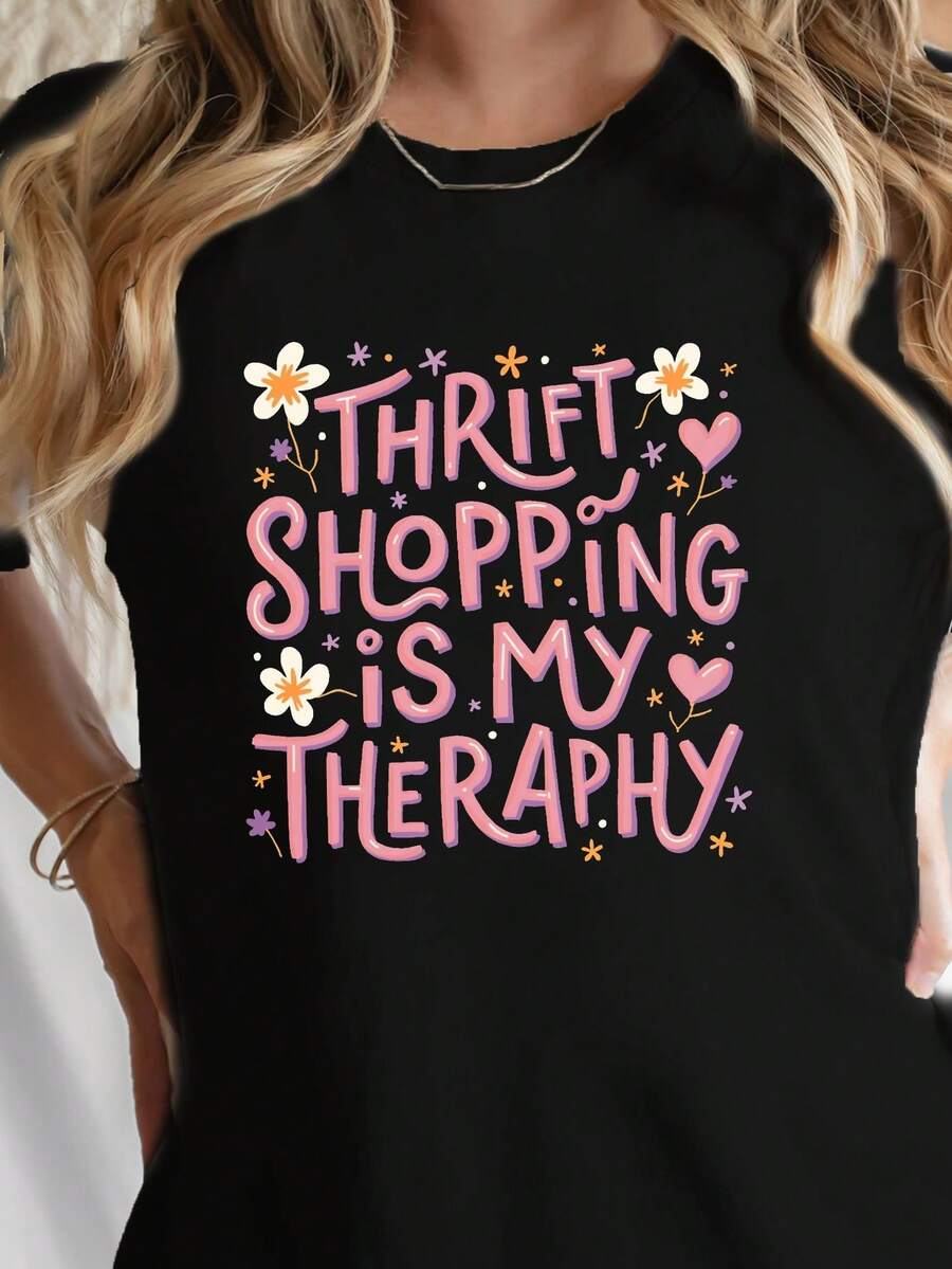 Premium es una camiseta casual de manga corta y cuello redondo, estampada con el mensaje "Comprar en tiendas de segunda mano es mi terapia", perfecta para la primavera y el verano, diseñada para mujeres. Esencial - Negro - Ver 1
