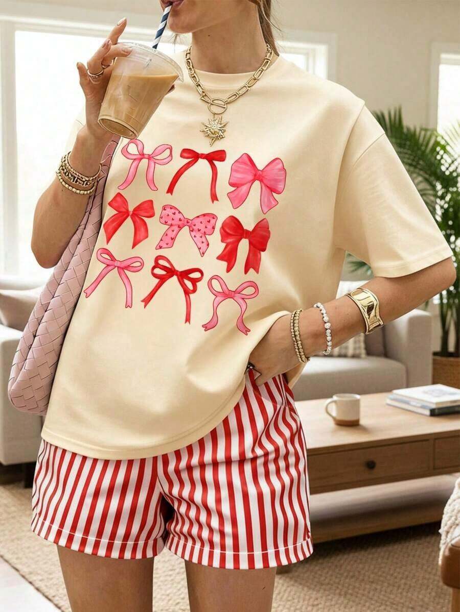Una camiseta de manga corta para mujer con estilo retro americano, de corte holgado y con diseño estampado (los pantalones son solo para sugerencias de estilo). Esta pieza sencilla y elegante presenta un patrón de letras impresas con temática tropical, lo que la convierte en un elemento imprescindible para crear un look relajado de vacaciones, perfecto para ocasiones como el Día del Trabajo y el Día de la Independencia de México. - Beige - Ver 1