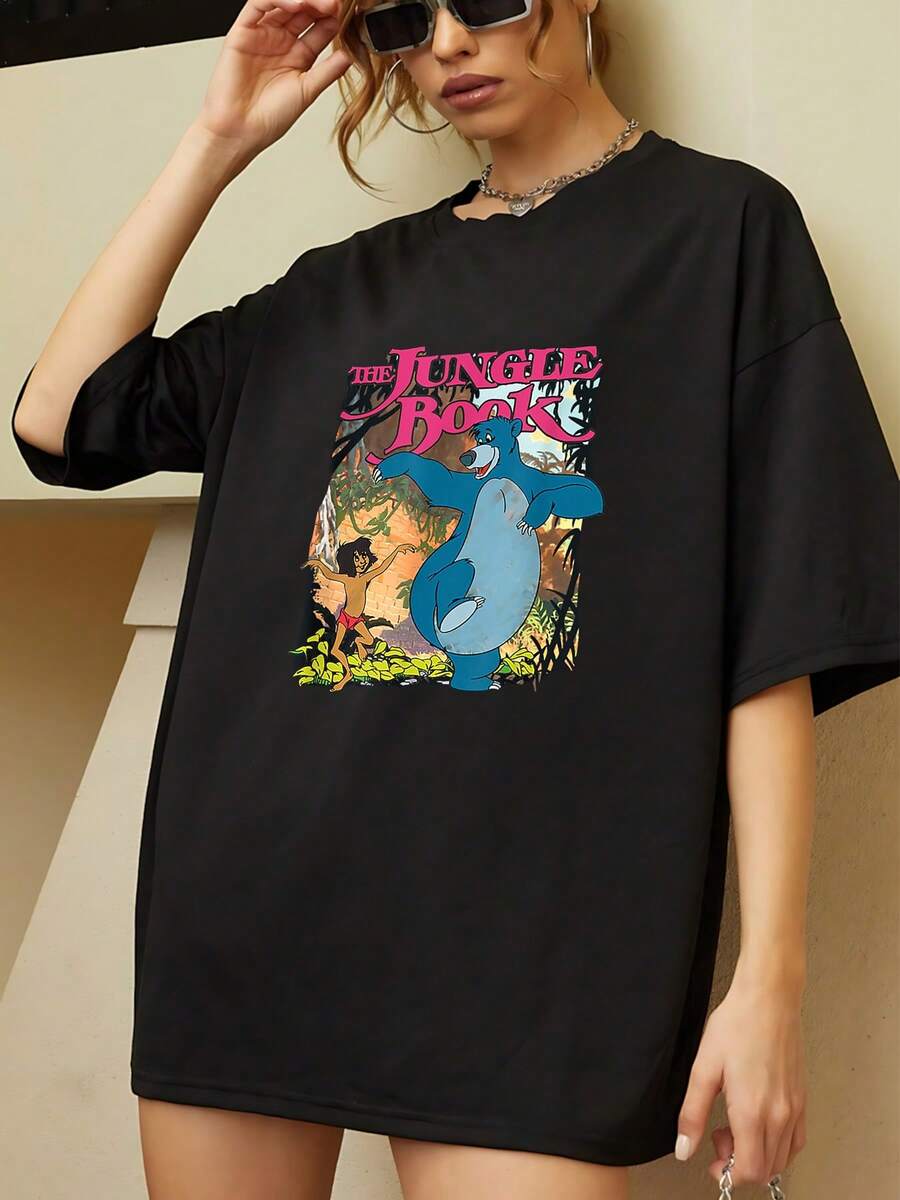 Vibrant Illustration Showing An Adventurous Boy And A Blue Bear Dancing In The Jungle, Symbolizing Freedom, Friendship, And Joy. Comfortable Casual Women's T-Shirt, Perfect For Everyday Wear. - 黑色 - 查看 1