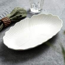 Este plato de pescado está disponible en múltiples tamaños y presenta exquisitos bordes ondulados de vieira y contornos de hojas, lo que le aporta un toque de elegancia moderna a tu mesa de comedor. El acabado blanco clásico complementa cualquier decoración de cocina y es perfecto para servir pescado entero, mariscos o aperitivos. - Blanco - Ver 7