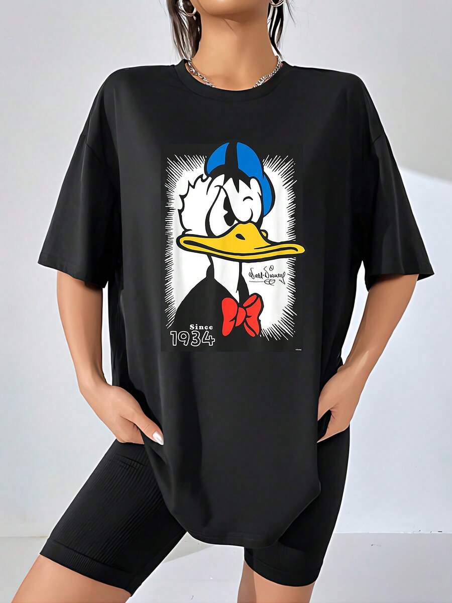 Imagen central que expresa la personalidad divertida y temperamental de un pato clásico con gorro azul y lazo rojo símbolo de vitalidad y humor desde 1934 camiseta de mujer suave cómoda perfecta para uso diario y estilo casual - Negro - Ver 1