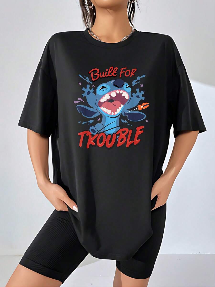 Gráfico de un personaje azul travieso que sonríe ampliamente lanzando pintura simbolizando energía alegría y espíritu libre ideal para expresar una personalidad divertida y audaz camiseta de mujer cómoda y casual - Negro - Ver 1