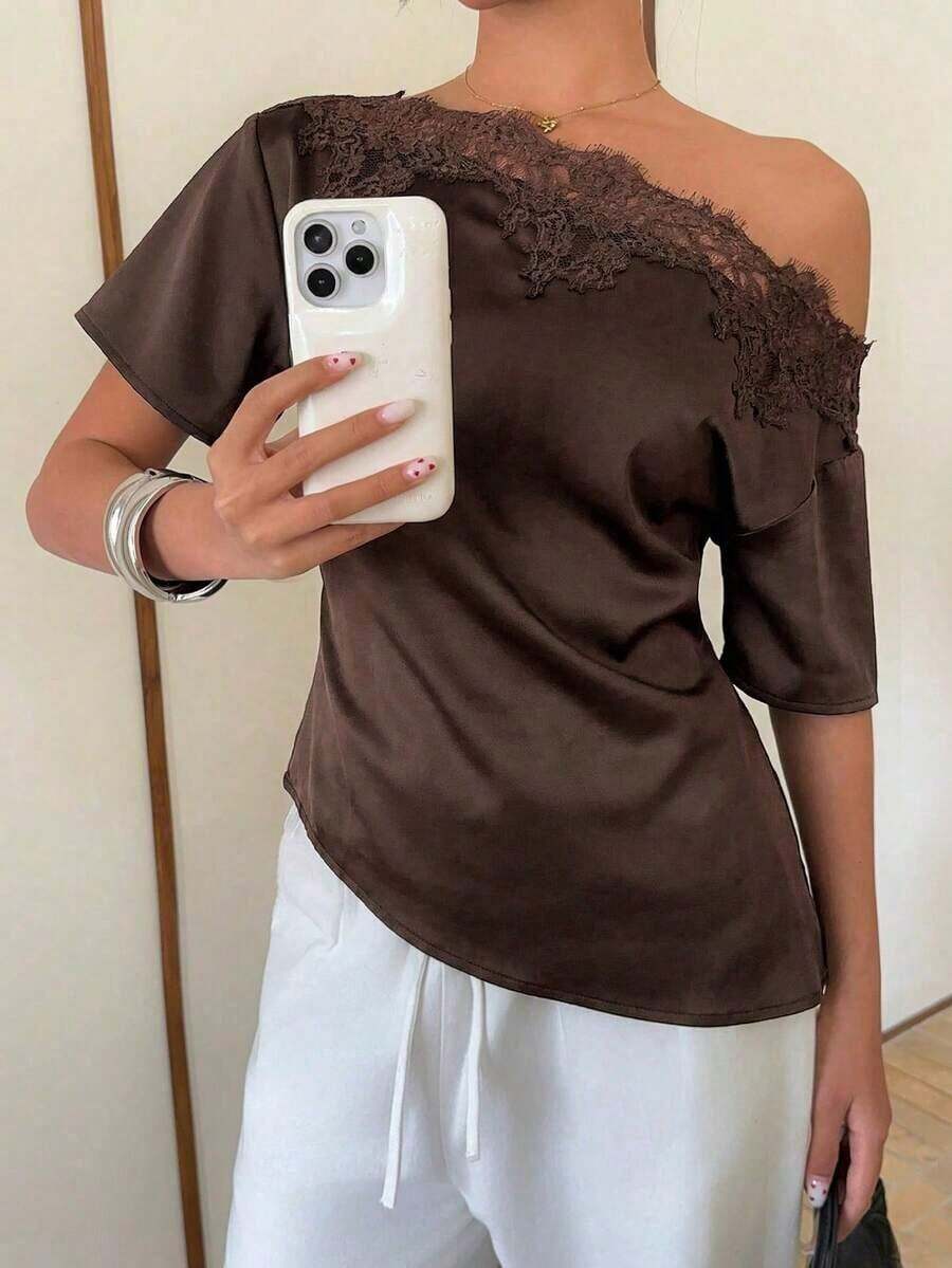 Elegante blusa de satén negro con escote asimétrico en el hombro y ribete de encaje.Esta camiseta de manga corta y bajo asimétrico presenta una silueta estilizadora y favorecedora, convirtiéndola en una opción elegante y versátil tanto para el - Marrón - Ver 1