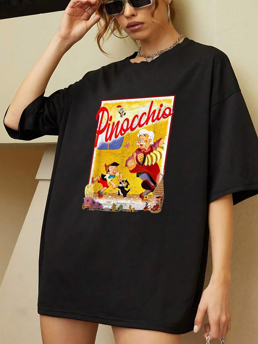 Colorful Illustration Showing A Cheerful Wooden Doll With Its Creator And Cat In A Nostalgic Scene Evoking The Innocence And Magic Of Classic Fairy Tales. Comfortable Casual Women's T-Shirt For Everyday Wear. - 黑色 - 查看 1