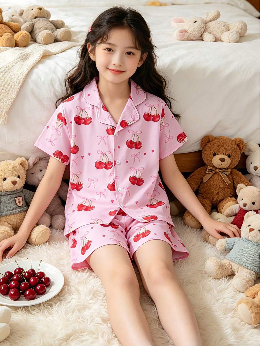 Conjunto de pijama infantil feminino de duas peças, com gola cardigã, estampa completa com laço e shorts de manga curta com estampa de cerejas. Ideal para uso diário, festas do pijama, momentos de lazer e também como presente de verão para crianças. - Baby Rosa - Ver 1